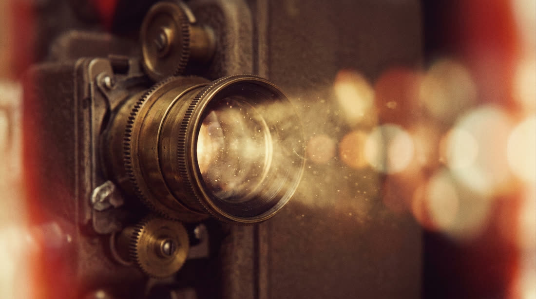 A vintage film projector lens catching a warm beam of light